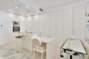 a white kitchen with a table and a chair at Fabulous Studio with Stunning Sea View by MK2 in Dubai