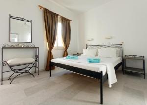 een slaapkamer met een bed, een stoel en een spiegel bij Ammosis Inn in Naxos Chora