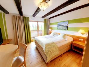 a bedroom with a bed and a desk and a television at Gasthof Thomann in Velden am Wörthersee