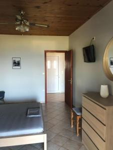 a room with a bed and a tv and a door at Aggeliki House 5 in Kómboi