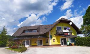 ein gelbes Haus mit braunem Dach in der Unterkunft Apartment Lucija-Terme Šmarješke Toplice in Smarjeske Toplice
