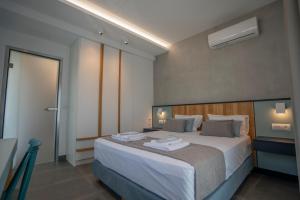 una camera da letto con un grande letto con lenzuola bianche di Tompazi 2 a Kavala