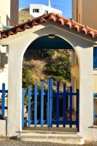 een blauwe poort voor een gebouw bij 3 Alpha Studios in Batsi