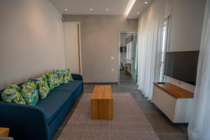a living room with a blue couch and a coffee table at Tompazi 2 in Kavala