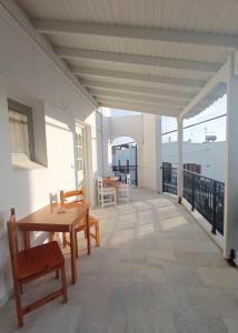 Habitación con balcón con mesa y sillas. en Ammosis Inn en Naxos
