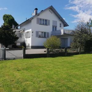 ein weißes Haus mit einem Zaun und einem Hof in der Unterkunft Ferienhaus Hämmerle´s in Lustenau