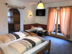 um quarto com duas camas e uma televisão num quarto em Gästehaus am Kurparkweg em Reit im Winkl