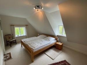 um quarto com uma cama e duas janelas em Gästehaus Zum Krug em Husum