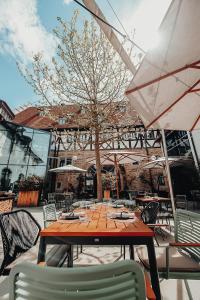 einen Holztisch mit Stühlen und einem Sonnenschirm auf einer Terrasse in der Unterkunft Hotel Freihof in Prichsenstadt