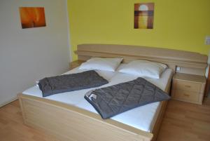 a bed with two pillows on it in a room at Ferienwohnungen am Plätlinsee in Wustrow