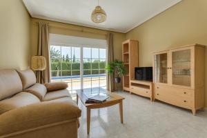 un soggiorno con divano e TV di Villa de Murcia - Relaxing Villa with Private Pool a Murcia