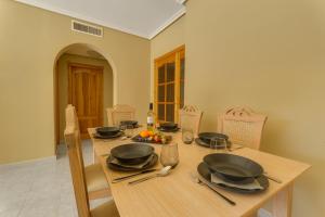 un tavolo in legno con piatti e utensili. di Villa de Murcia - Relaxing Villa with Private Pool a Murcia