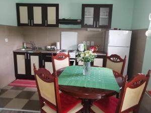 Airplane Apartment T&T في Surčin: مطبخ مع طاولة عليها إناء من الزهور