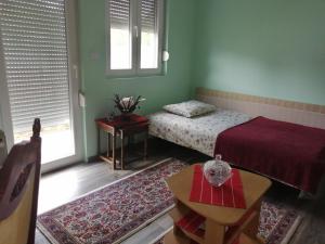 a bedroom with a bed and a table and a window at Airplane Apartment T&T in Surčin