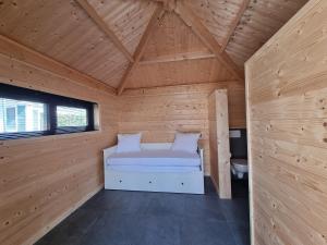 Cette chambre comprend un lit dans une cabane en bois. dans l'établissement Chalet aan de Oosterschelde met Airconditioning!, à Sint-Annaland