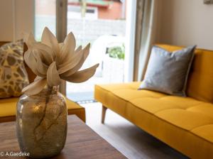 a vase with a flower on a table in a living room at Apartments zur alten Konditorei in Schwerin +23 photos
