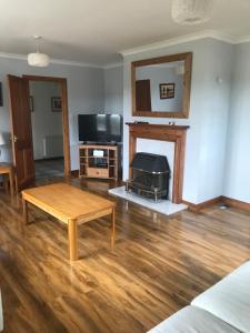 a living room with a table and a fireplace at Brackenbrae Holiday Cottage in Acharacle
