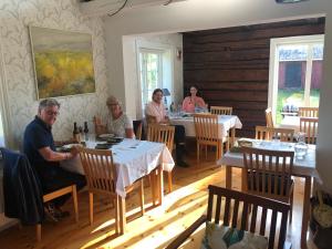 a group of people sitting at tables in a restaurant at STF Kungsgården Långvind in Enånger