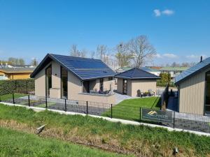 une rangée de maisons dotées de panneaux solaires dans l'établissement Chalet aan de Oosterschelde met Airconditioning!, à Sint-Annaland