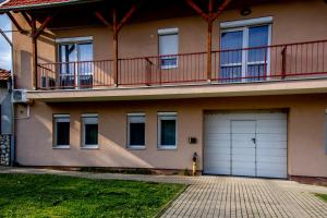 a house with two garage doors and a balcony at Family Residence in Eger
