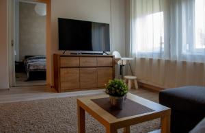 a living room with a flat screen tv on a dresser at Family Residence in Eger