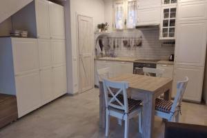 a kitchen with a wooden table and chairs in it at Serenity Cottage Feriolo in Baveno