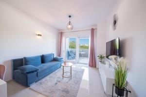 a living room with a blue couch and a tv at Romanca in Zadar