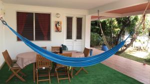 un'amaca su un patio con tavolo e sedie di Hibiscus a Le Diamant