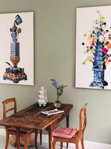 a dining room with a wooden table and two vases at HOMESTEAD Amsterdam in Amsterdam