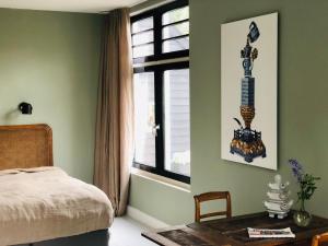 Schlafzimmer mit einem Bett, einem Tisch und einem Fenster in der Unterkunft HOMESTEAD Amsterdam in Amsterdam