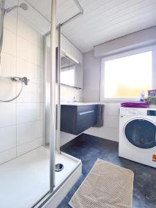 a bathroom with a washer and a washing machine at Auszeit vom Alltag- schöne, moderne Wohnung am See in Immenstaad am Bodensee