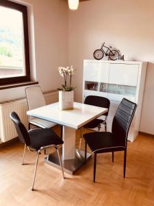 a dining room with a white table and chairs at Ferienwohnung Resi mit traumhaftem Seepanorama in Steindorf am Ossiacher See
