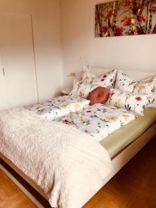 シュタインドルフ・アム・オシアッハー・ゼーにあるFerienwohnung Resi mit traumhaftem Seepanoramaのベッド(白い掛け布団、枕付)