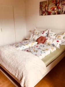 a bed with a white comforter and pillows on it at Ferienwohnung Resi mit traumhaftem Seepanorama in Steindorf am Ossiacher See