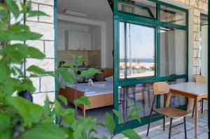uma cozinha e sala de jantar com uma mesa e uma janela em Apartments Ivica - Beachfront em Drvenik