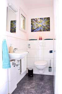 a white bathroom with a sink and a toilet at Auszeit vom Alltag- schöne, moderne Wohnung am See in Immenstaad am Bodensee +13 photos