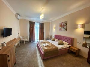 a hotel room with a bed and a television at Кайзервальд Карпати in Karpaty