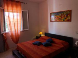 um quarto com uma cama vermelha com duas almofadas em Relax Torre lapillo em Torre Lapillo