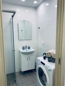 Un baño con lavadora y lavabo. en Bastion Apartment, en Narva