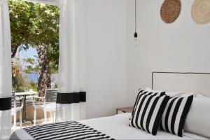 ein Schlafzimmer mit Bett und Blick auf eine Terrasse in der Unterkunft High Mill Hotel by Mr and Mrs White in Parikia