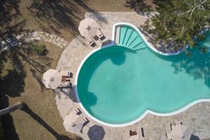 Draufsicht auf ein Schwimmbecken mit Sonnenschirmen in der Unterkunft High Mill Hotel by Mr and Mrs White in Parikia