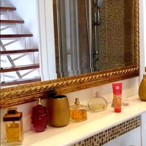 a bathroom shelf with a mirror and some bottles at Burano Cà Comare in Burano +31 photos