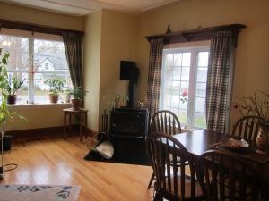 een eetkamer met een tafel en twee ramen bij B&B Art of Germany in Caledonia