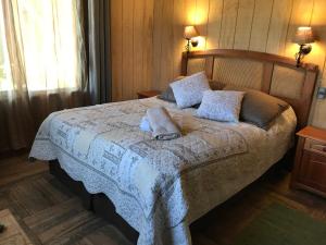 ein Schlafzimmer mit einem Bett mit zwei Kissen darauf in der Unterkunft Cabańas de La Ochi in Niebla