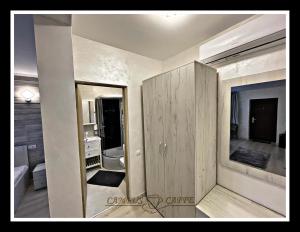 a bathroom with a large mirror next to a room at Cabana Campus Caffe - Camere Individuale in Sările