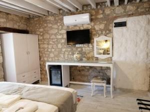 a bedroom with a bed and a tv on the wall at kaktüshan otel in Alaçatı