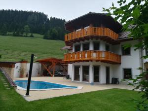 a house with a balcony and a swimming pool at Ferienwohnung Hackstock in Lunz am See