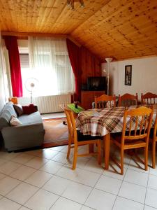 a living room with a table and chairs and a couch at Borostyán Apartmann in Balatonföldvár