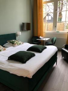 Numansdorp的住宿－Schuringse Klasse，一间卧室配有一张大床和枕头