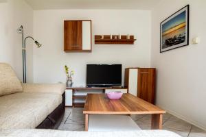 a living room with a couch and a table with a tv at Oleander in Portorož